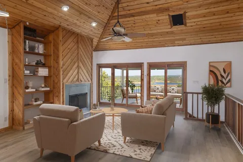 a living room with furniture a fireplace and a floor to ceiling window