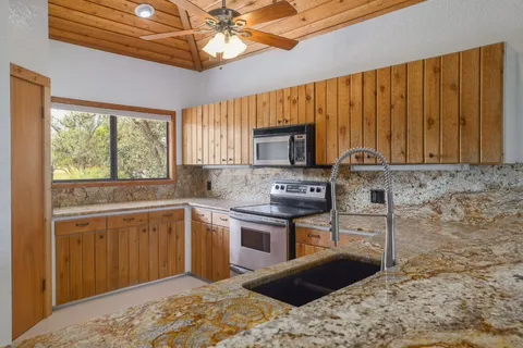 a kitchen with stainless steel appliances granite countertop a sink stove and microwave