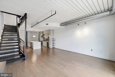 a view of a livingroom with wooden floor and staircase