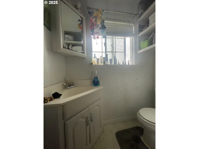 a bathroom with a sink toilet and window