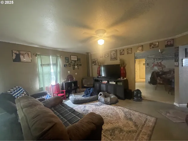 a living room with furniture a flat screen tv and a large window