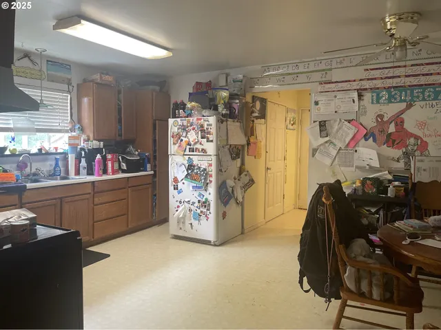 a kitchen with granite countertop a refrigerator and cabinets