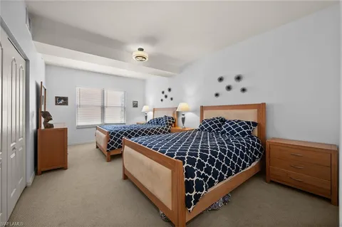 a bedroom with a bed and large windows