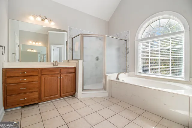 a spacious bathroom with a granite countertop sink mirror and a bathtub