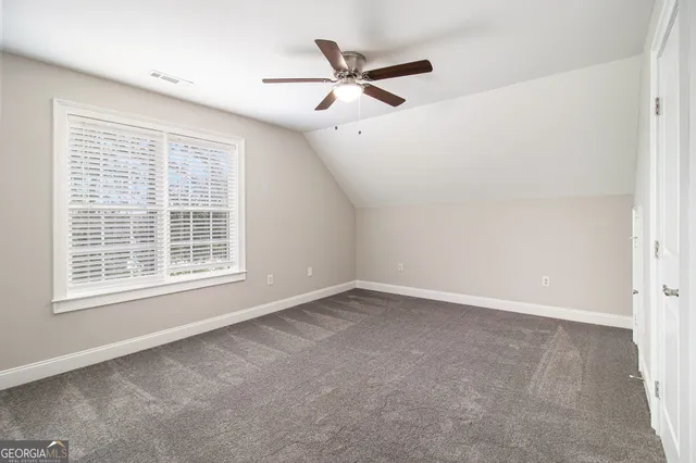 an empty room with a ceiling fan and window