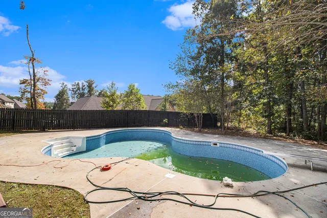 a small pool with some tall trees