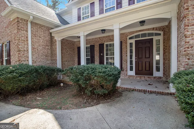 front view of a brick house with potted plants