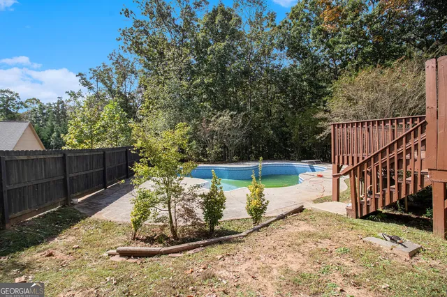 a view of a backyard with wooden fence