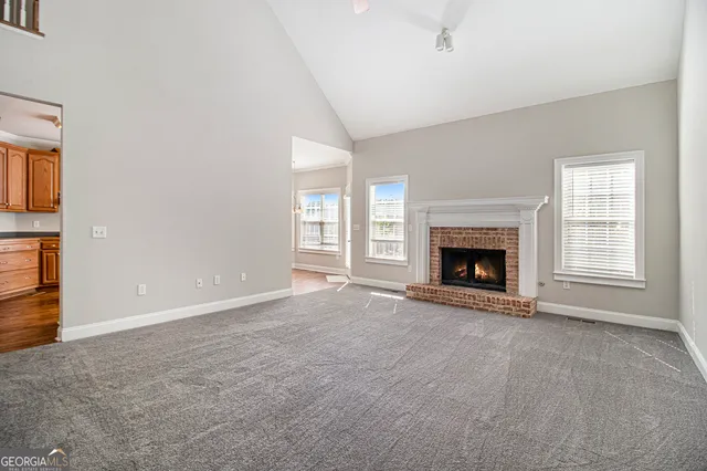 an empty room with windows and fireplace