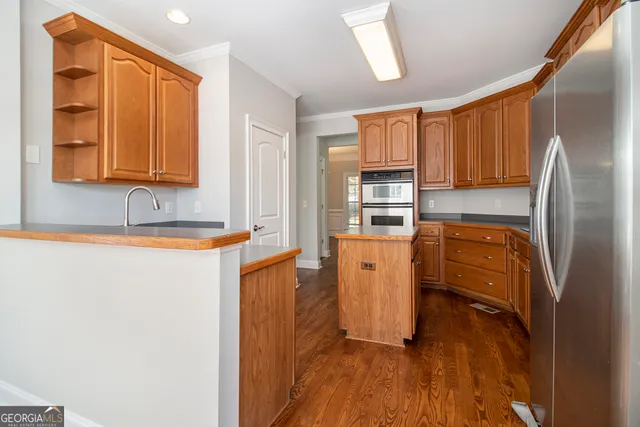 a kitchen with granite countertop wooden floors and stainless steel appliances