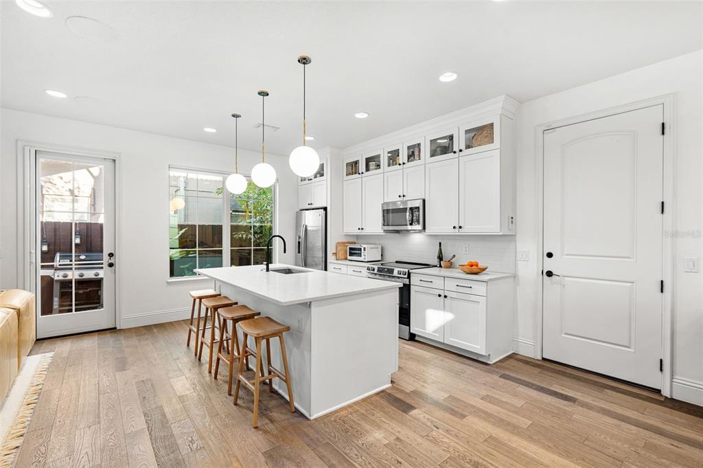 1732 Ridgewood Avenue, Unit S Maitland, FL 32751 - Photo 13 of 31 a kitchen with stainless steel appliances a stove top oven a sink dishwasher and a refrigerator with wooden floor