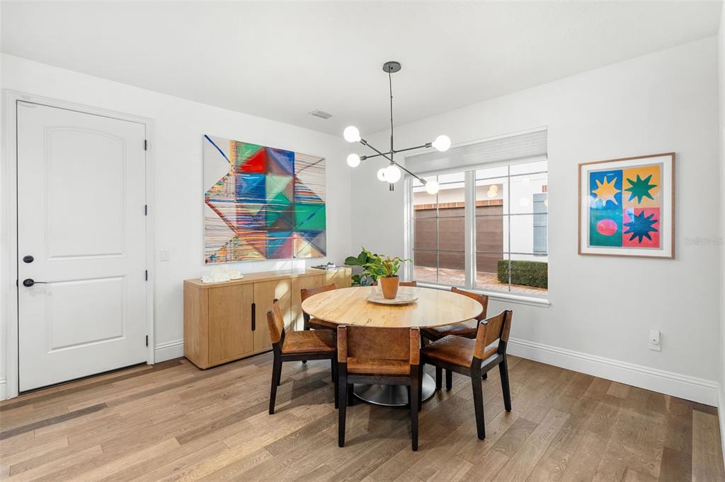 1732 Ridgewood Avenue, Unit S Maitland, FL 32751 - Photo 14 of 31 a view of a dining room with furniture a chandelier and wooden floor