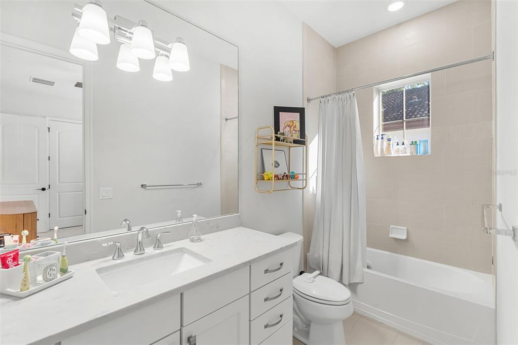 1732 Ridgewood Avenue, Unit S Maitland, FL 32751 - Photo 24 of 31 a bathroom with a granite countertop sink a toilet and a mirror