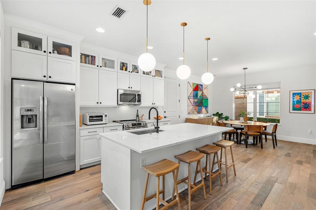 1732 Ridgewood Avenue, Unit S Maitland, FL 32751 - Photo 8 of 31 a kitchen with stainless steel appliances granite countertop a stove a kitchen island a dining table and chairs