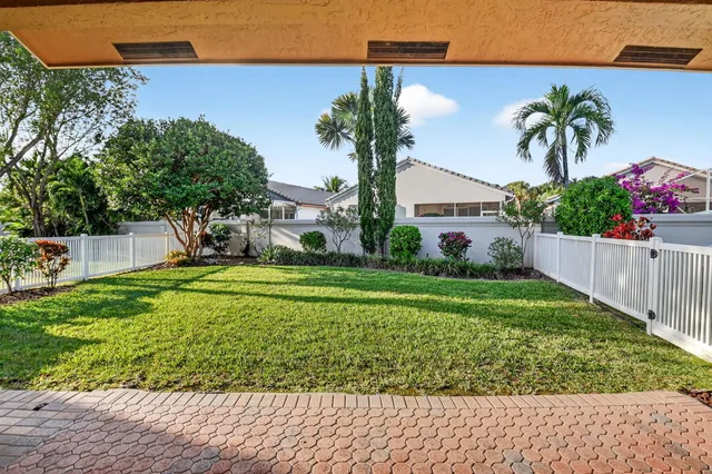 a front view of a house with a yard and potted plants