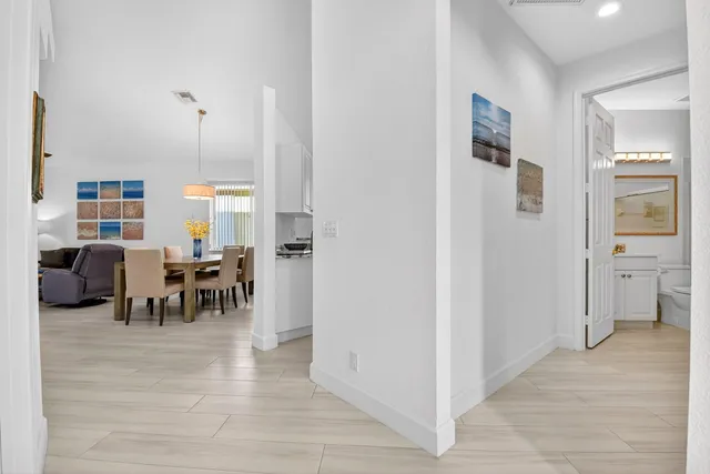 a view of a dining room and livingroom with furniture wooden floor a chandelier