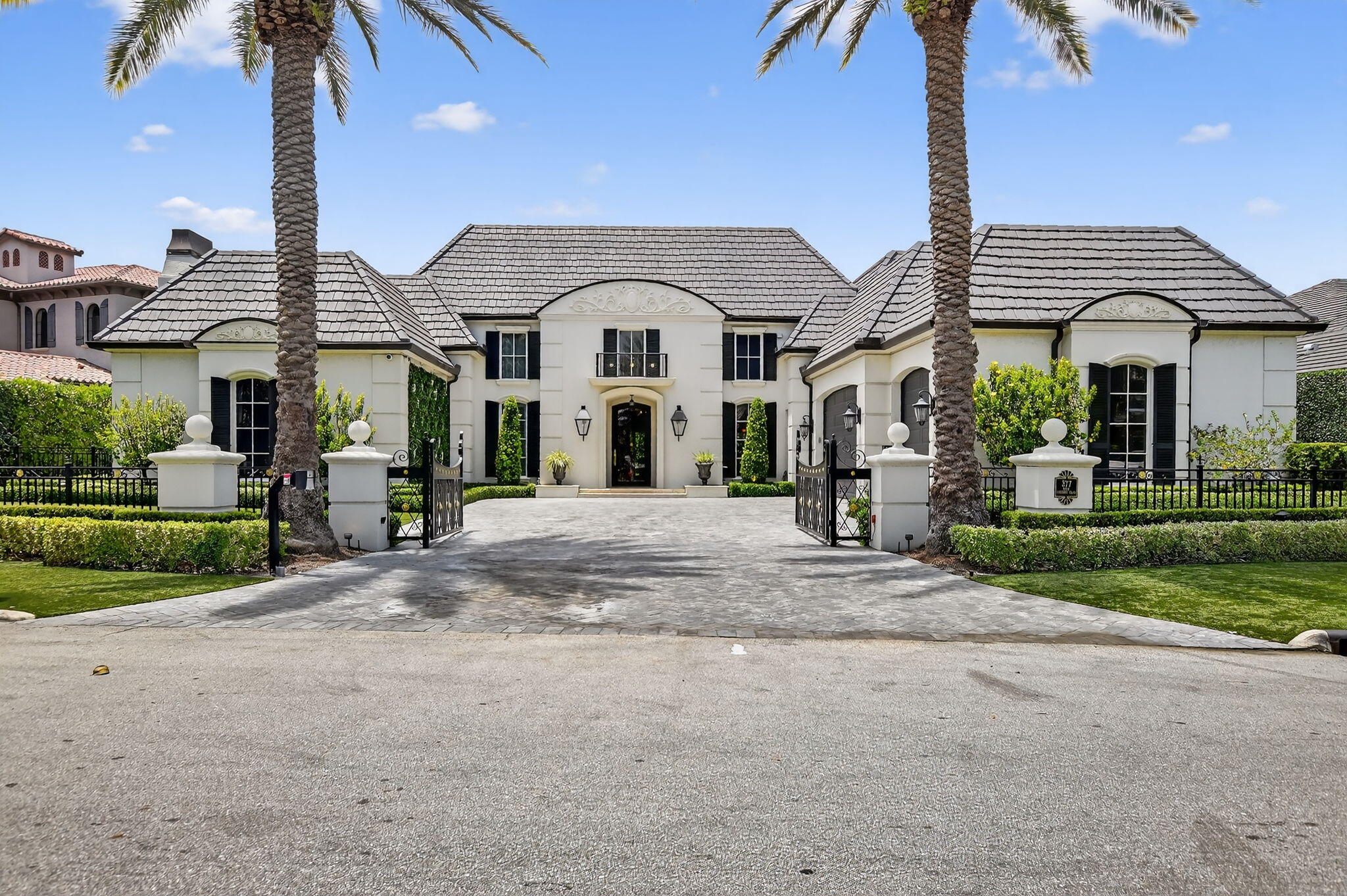 377 East Coconut Palm Road Boca Raton, FL 33432 - Photo 113 of 113 a view of a white house with a fountain and a palm tree