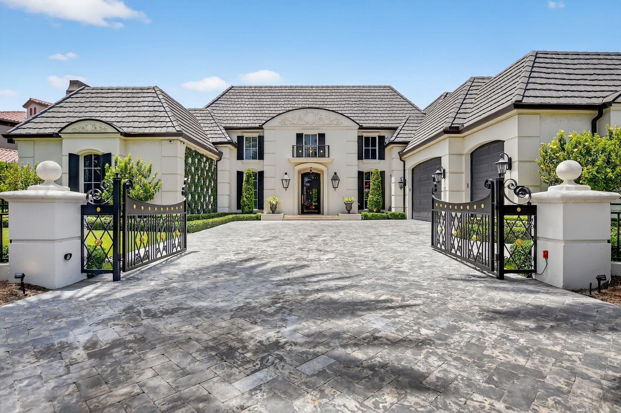377 East Coconut Palm Road Boca Raton, FL 33432 - Photo 2 of 113 a view of a house with large windows and a small yard