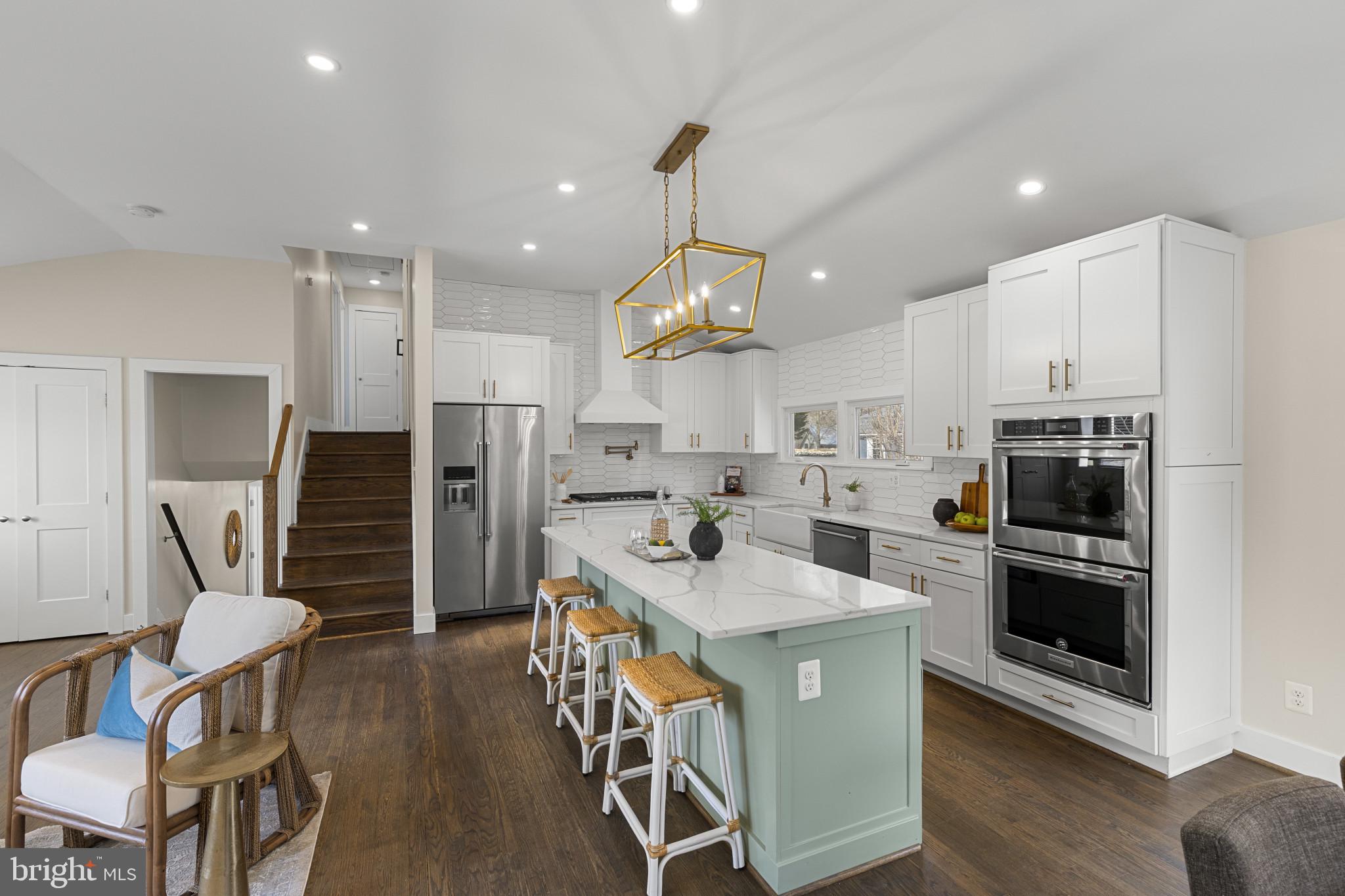 1519 Winchester Road Annapolis, MD 21409 - Photo 6 of 34 a kitchen with stainless steel appliances kitchen island granite countertop a refrigerator a stove a sink a dining table and chairs with wooden floor