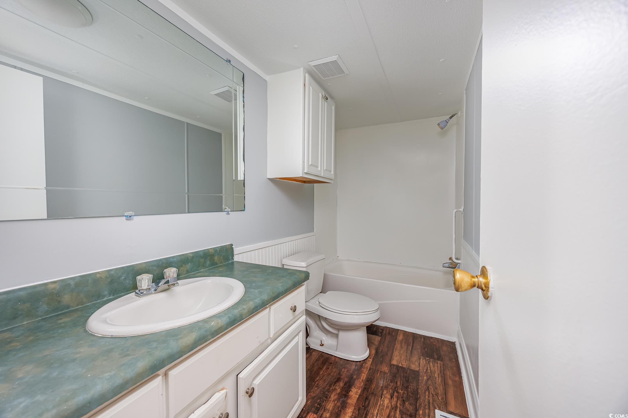 193 Nollie Road Myrtle Beach, SC 29588 - Photo 22 of 35 Full bath with vanity, dark wood-style flooring, bathtub / shower combination, and a wainscoted wall