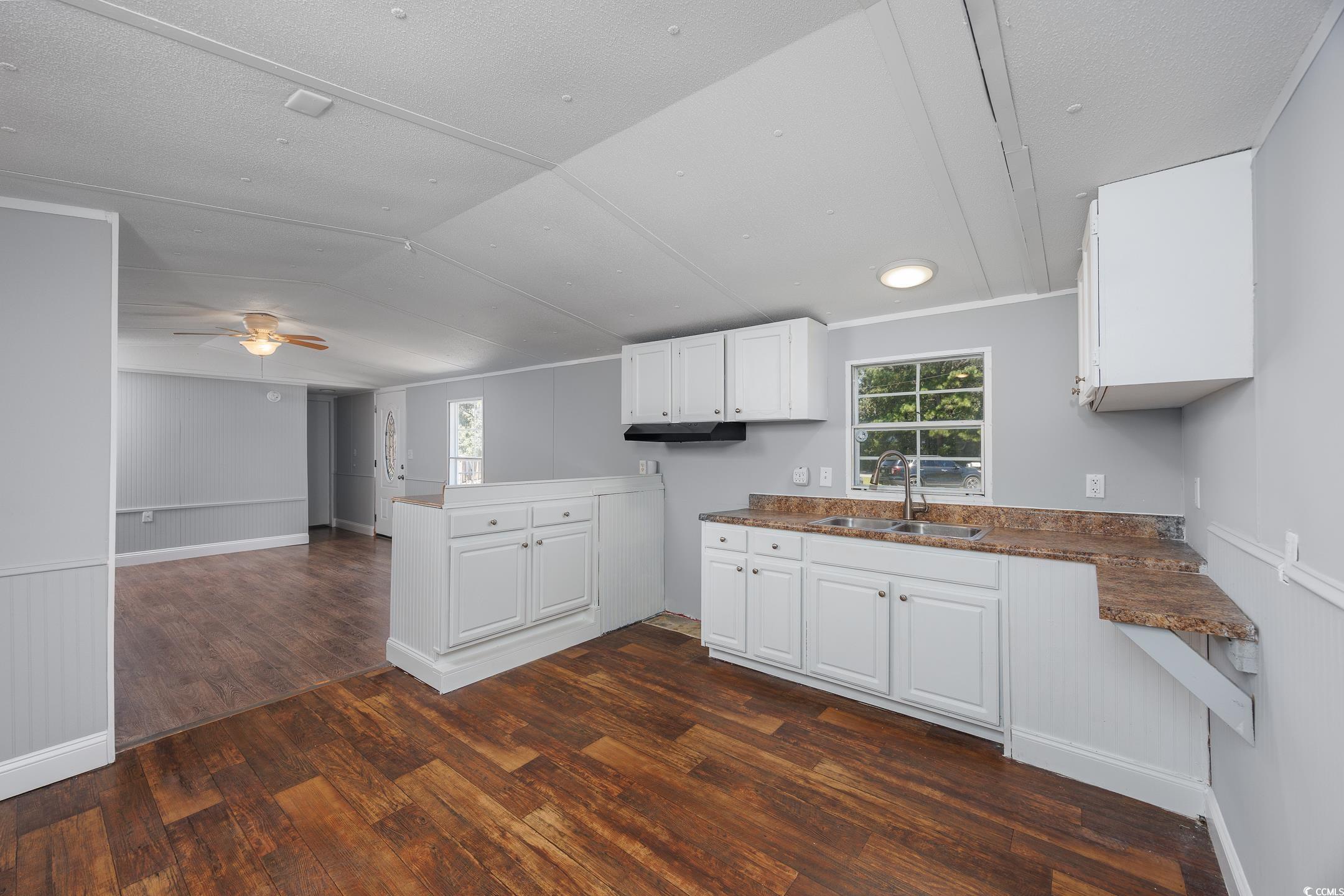 193 Nollie Road Myrtle Beach, SC 29588 - Photo 35 of 35 Kitchen featuring white cabinetry, dark wood-style flooring, open floor plan, a peninsula, and lofted ceiling