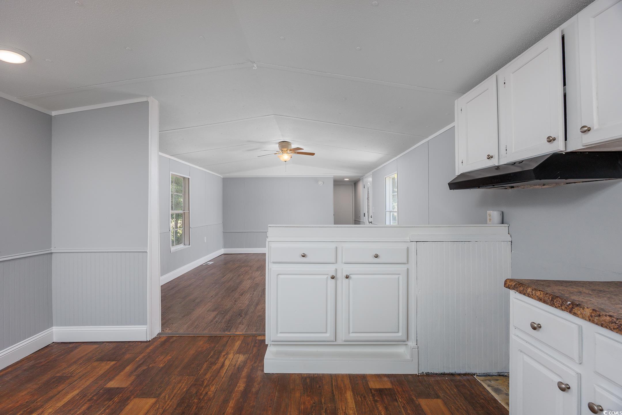 193 Nollie Road Myrtle Beach, SC 29588 - Photo 30 of 35 Kitchen with dark wood finished floors, white cabinets, healthy amount of natural light, a peninsula, and vaulted ceiling