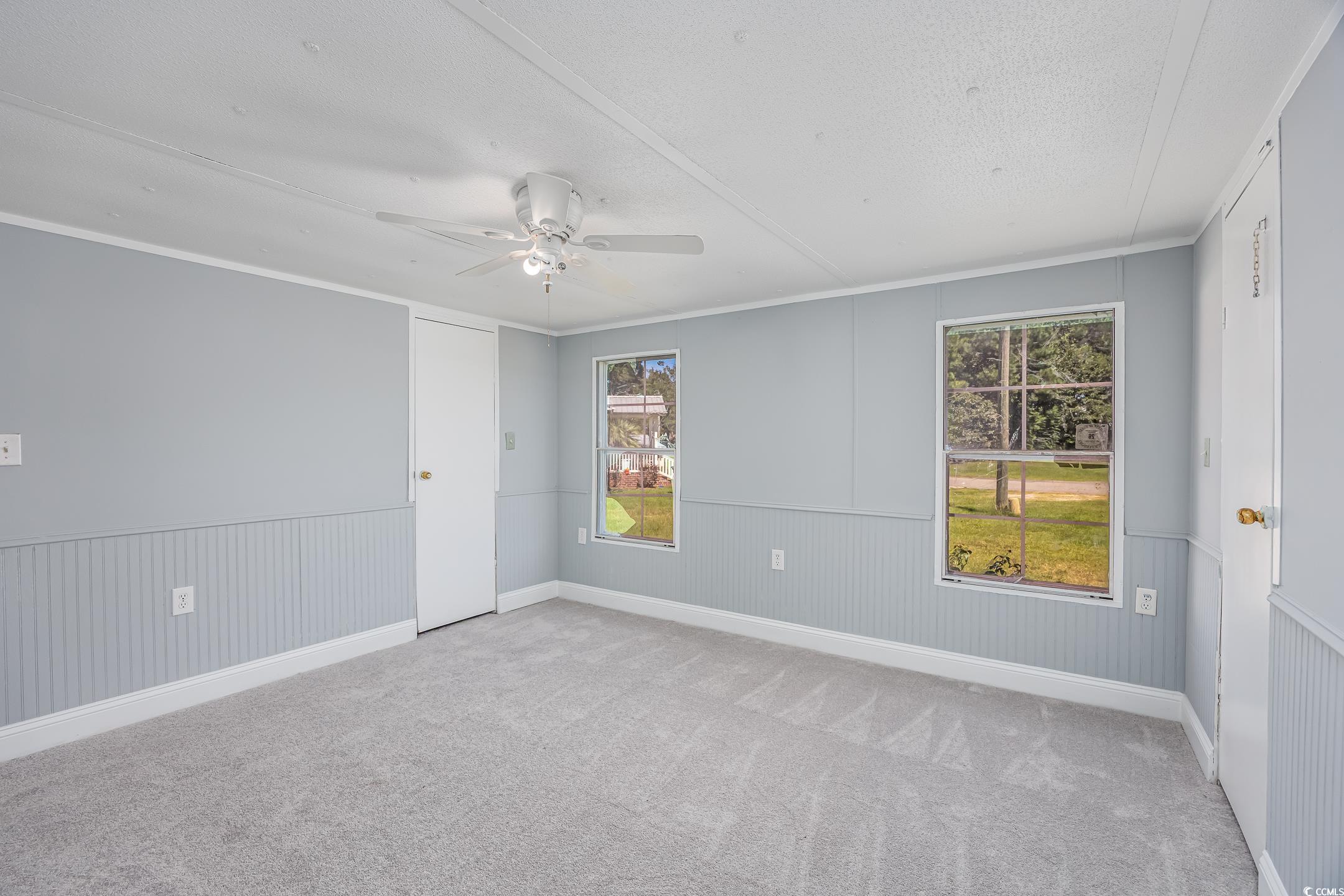 193 Nollie Road Myrtle Beach, SC 29588 - Photo 33 of 35 Carpeted spare room featuring crown molding, ceiling fan, and wainscoting