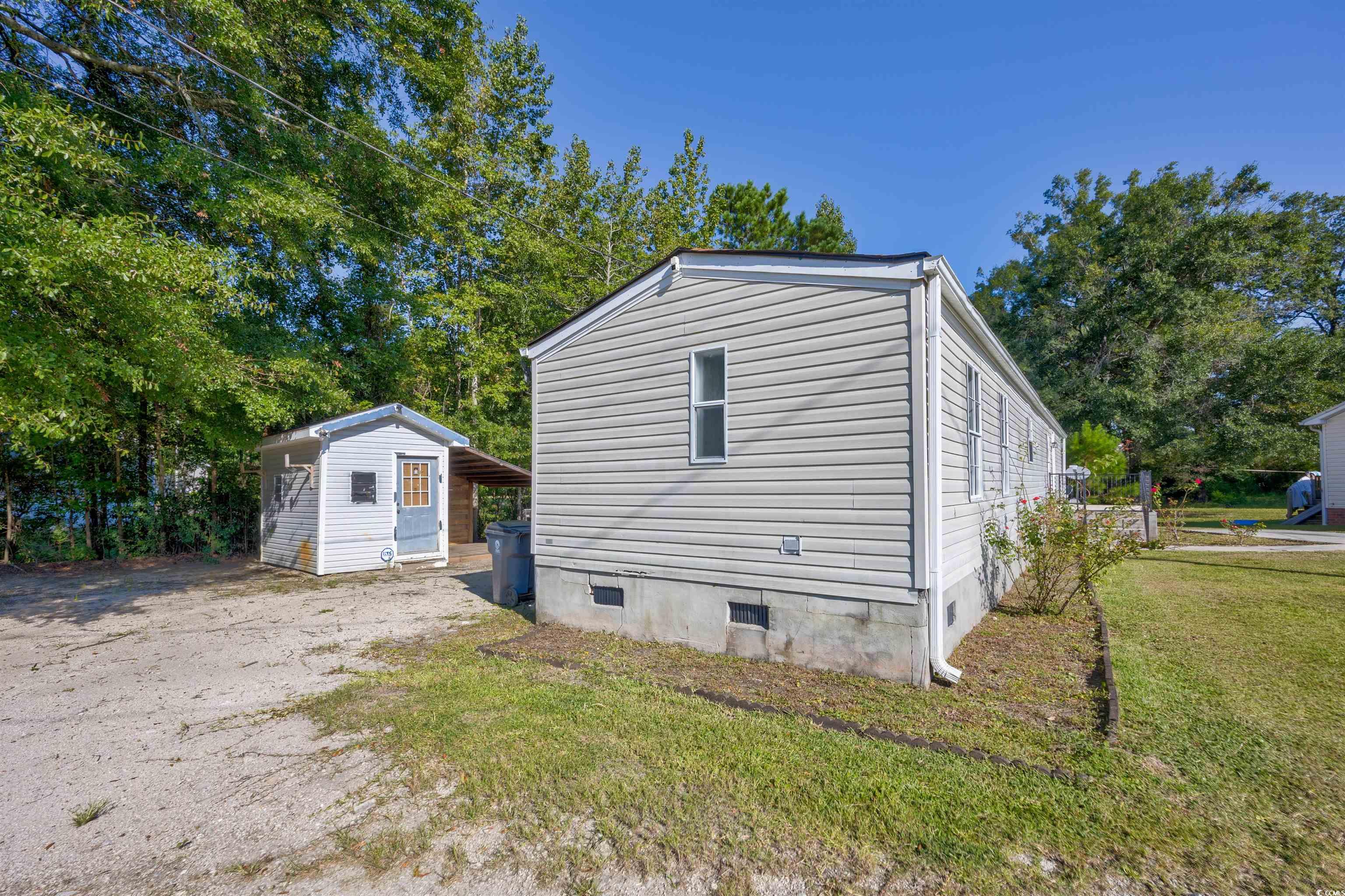 193 Nollie Road Myrtle Beach, SC 29588 - Photo 3 of 35 View of home's exterior with crawl space, an outbuilding, and a lawn
