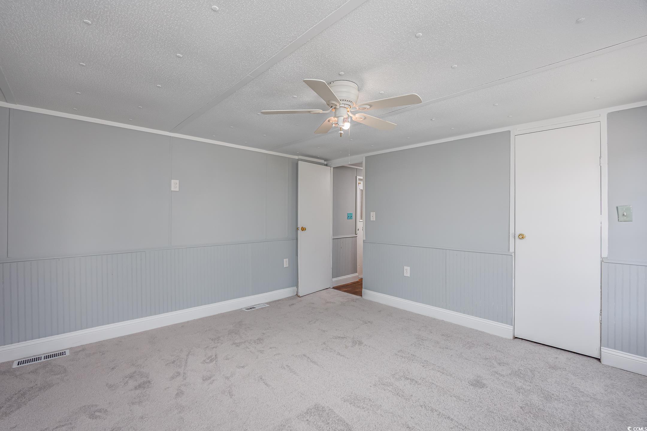193 Nollie Road Myrtle Beach, SC 29588 - Photo 8 of 35 Carpeted empty room featuring ceiling fan and a textured ceiling