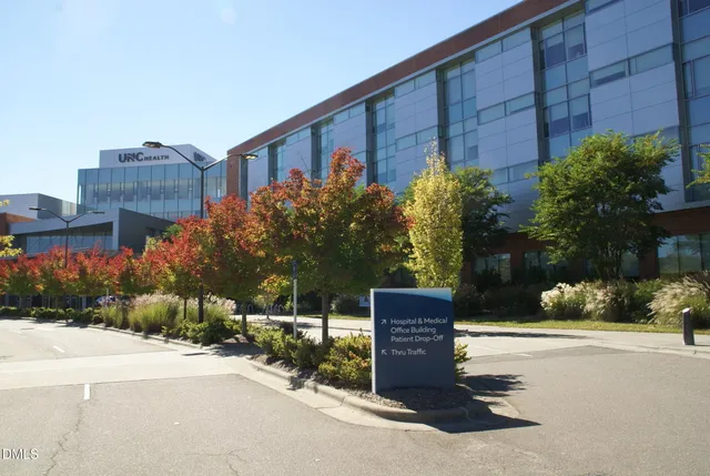 a sign board with flower garden in front of it