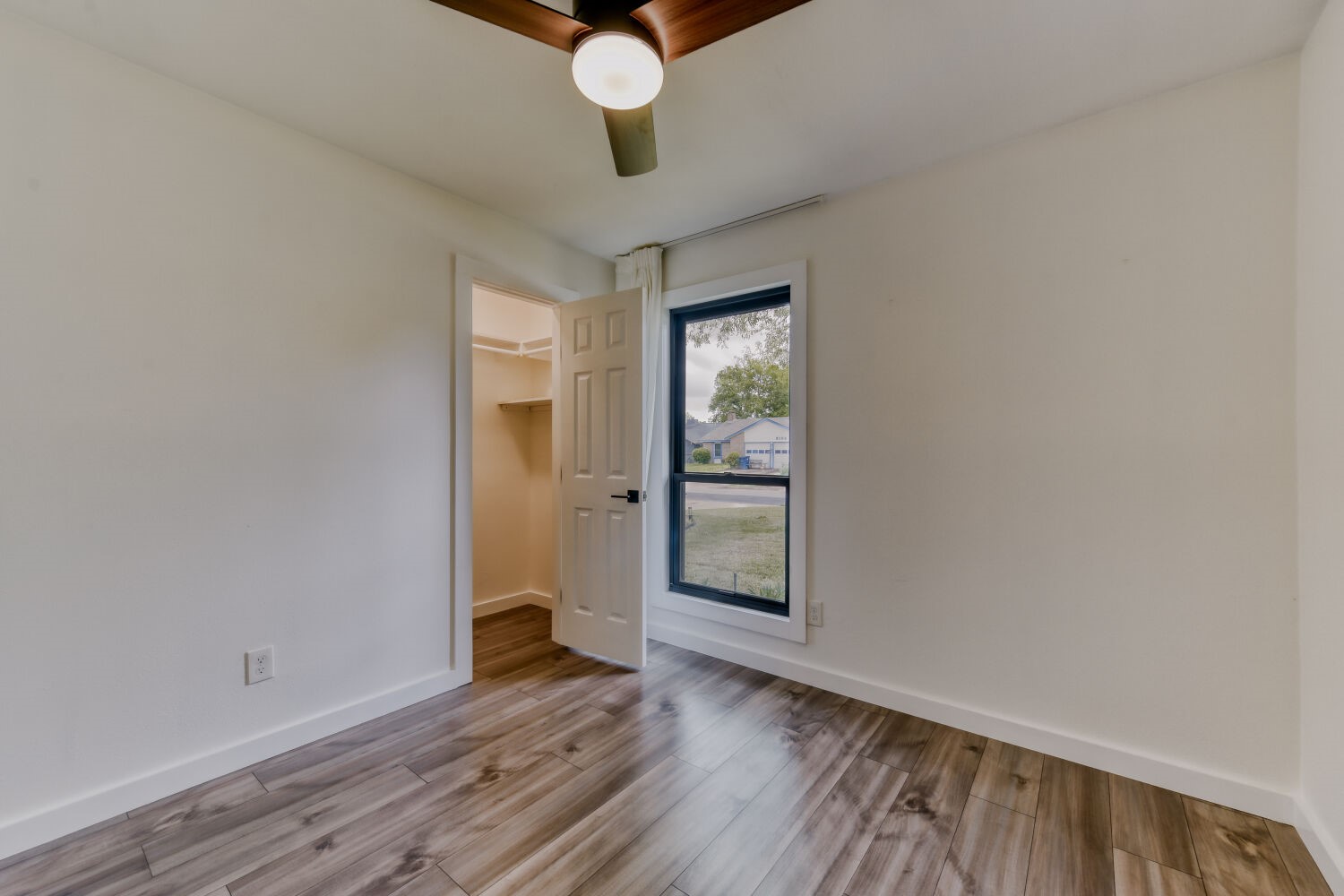 6108 Bridlington Circle Austin, TX 78745 - Photo 16 of 22 a view of an empty room with a window and wooden floor