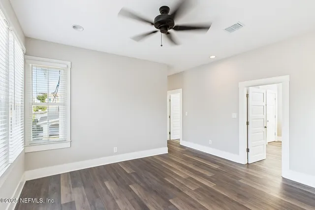 a view of a room with a ceiling fan and wooden floor