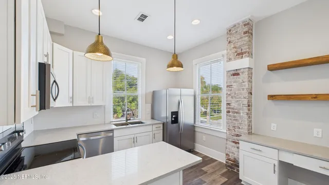 a kitchen with stainless steel appliances granite countertop a refrigerator a sink and a cabinets