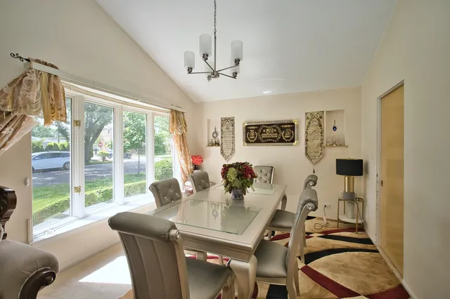 a view of a dining room with furniture a chandelier and wooden floor