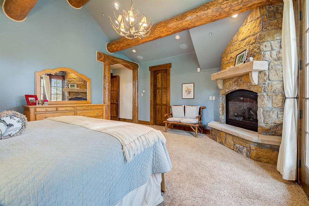350 Timbertrail Road Breckenridge, CO 80424 - Photo 14 of 35 a bedroom with a bed a chandelier and dresser