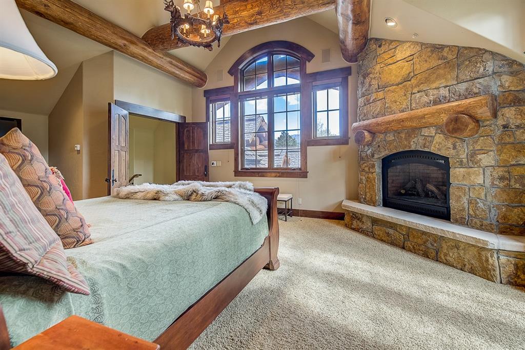 350 Timbertrail Road Breckenridge, CO 80424 - Photo 19 of 35 a spacious bedroom with a bed and a fireplace