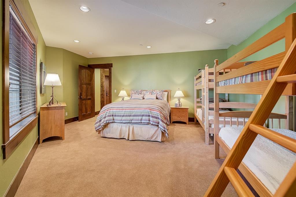 350 Timbertrail Road Breckenridge, CO 80424 - Photo 31 of 35 a spacious bedroom with a large bed and a chandelier