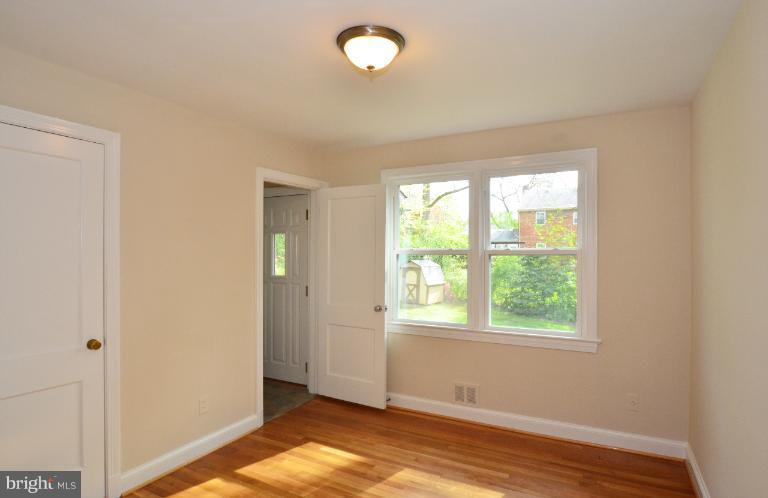 10105 Portland Place Silver Spring, MD 20901 - Photo 4 of 11 a view of an empty room with wooden floor and a window