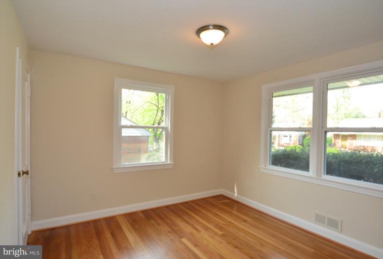 10105 Portland Place Silver Spring, MD 20901 - Photo 7 of 11 an empty room with wooden floor and windows
