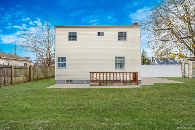 a view of a house with a yard and a bench