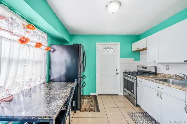 a kitchen with granite countertop a stove a sink and a refrigerator