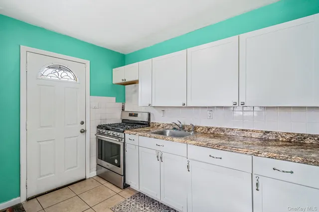 a kitchen with granite countertop white cabinets and white appliances