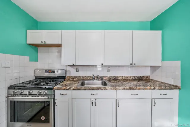 a kitchen with a stove a white cabinets and a stove