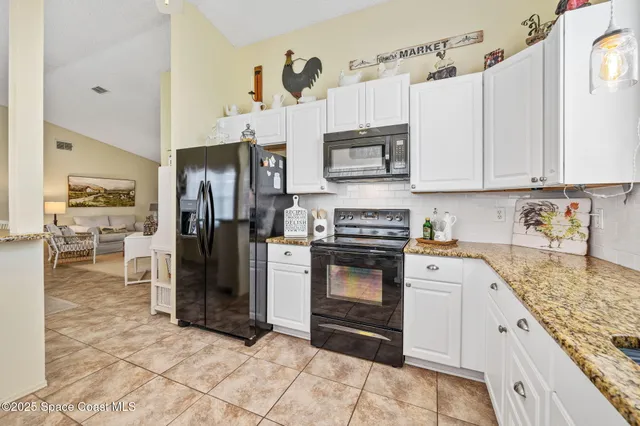 a kitchen with stainless steel appliances granite countertop a refrigerator stove and sink