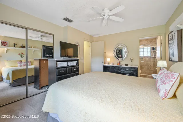 a spacious bedroom with a bed and a flat screen television