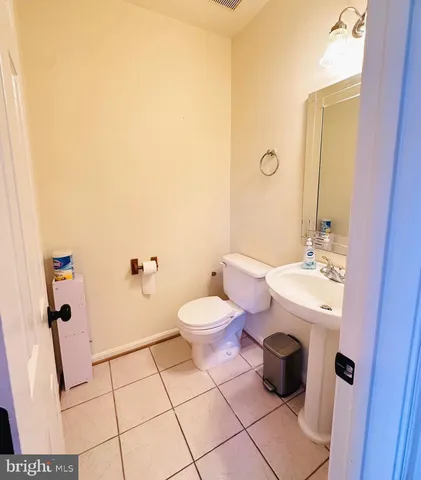 a bathroom with a granite countertop toilet a sink and a mirror