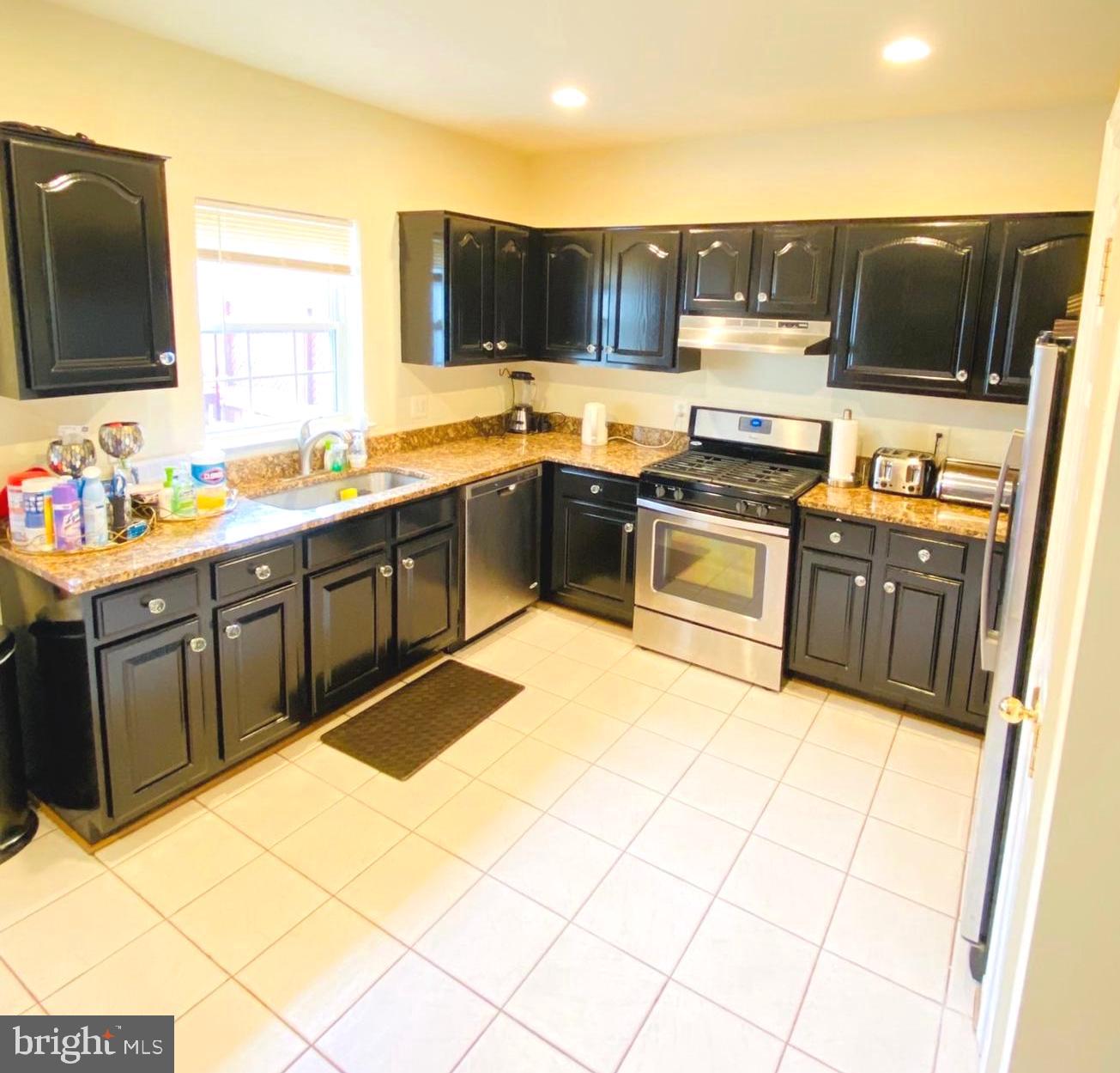 43005 Beachall Street Chantilly, VA 20152 - Photo 8 of 28 a kitchen with stainless steel appliances granite countertop a stove top oven a sink dishwasher and a refrigerator with wooden floor