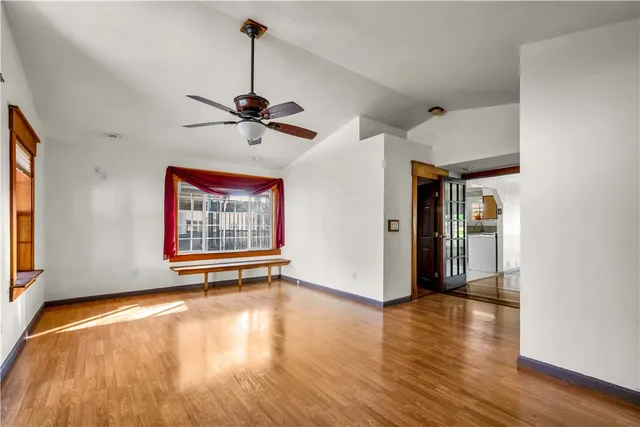a view of empty room with wooden floor and floor to ceiling window