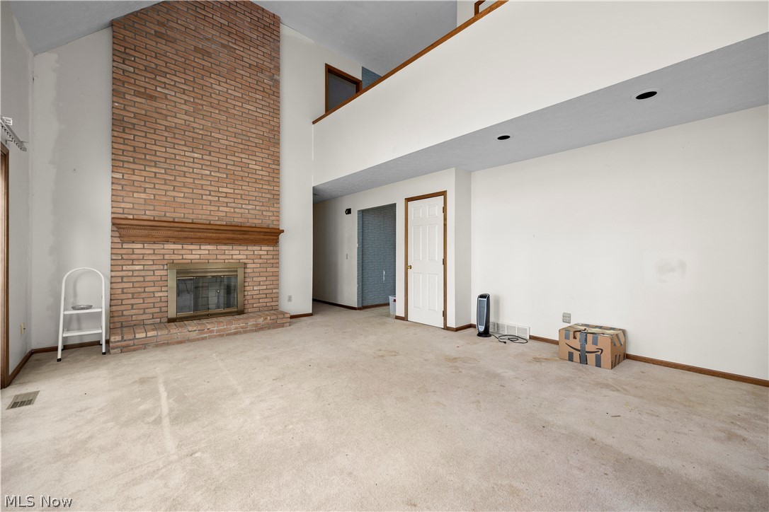 722 Jaycox Road Avon Lake, OH 44012 - Photo 5 of 48 Spacious living area featuring a floor-to-ceiling brick fireplace with a wood mantle, vaulted ceilings, and recessed lighting