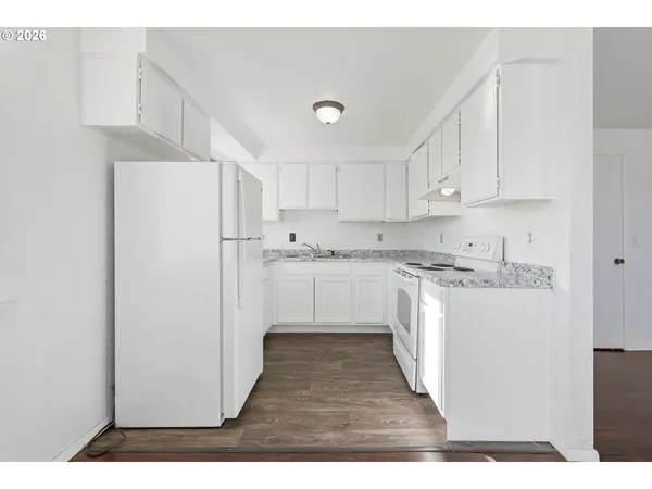 a kitchen with white cabinets and white appliances
